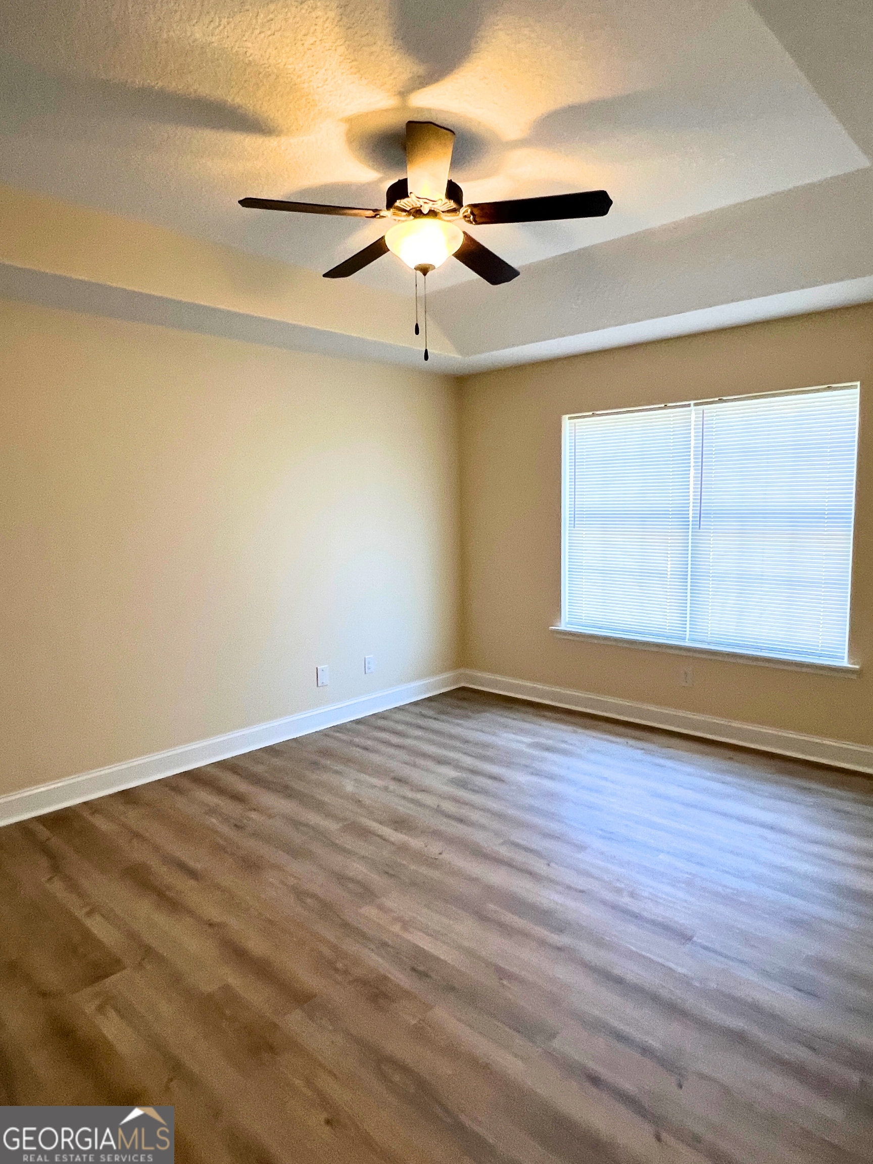 818 Davis Avenue Kingsland, GA 31548 - Photo 13 of 29 an empty room with wooden floor chandelier fan and windows