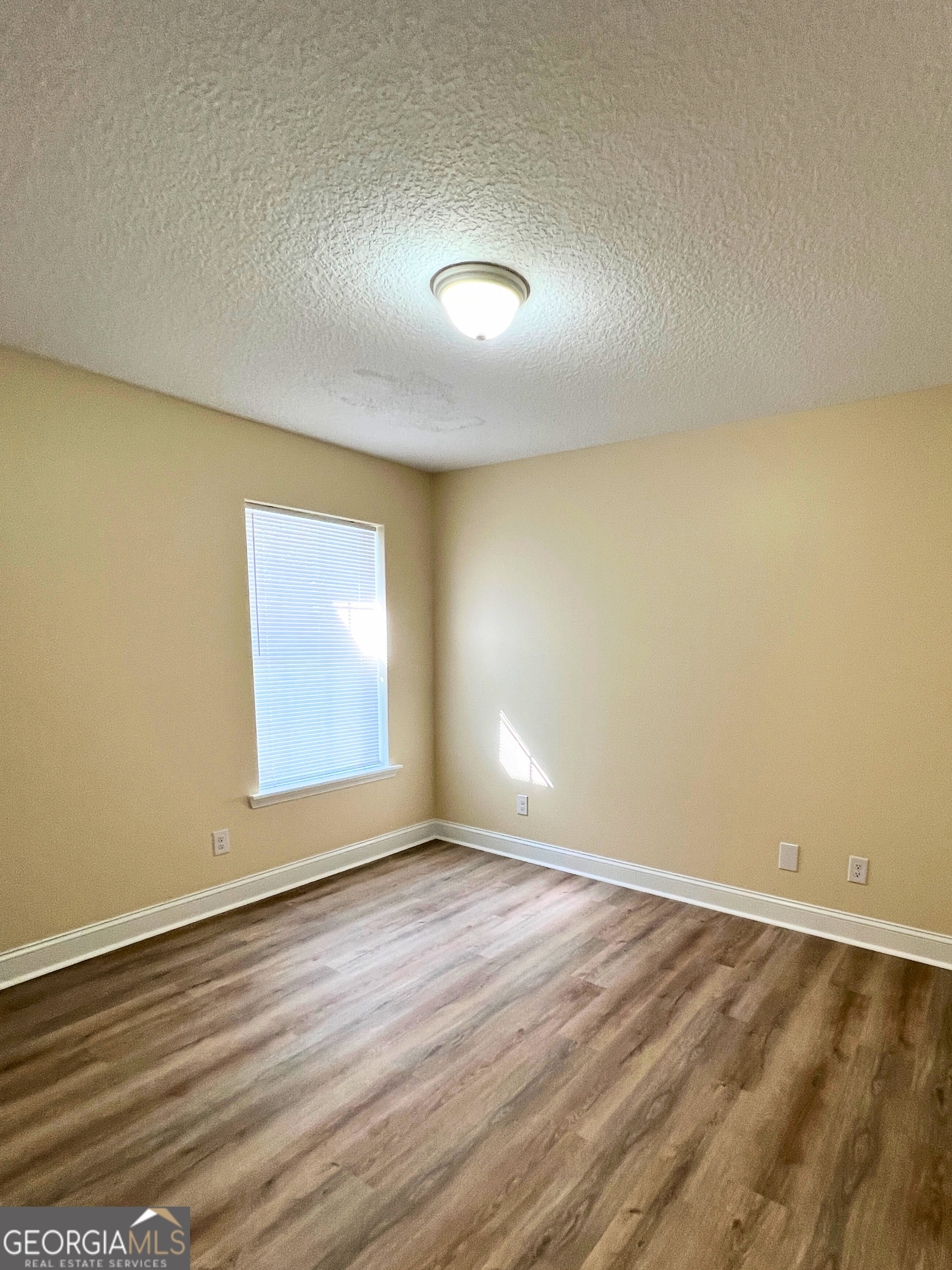 818 Davis Avenue Kingsland, GA 31548 - Photo 18 of 29 an empty room with wooden floor and windows