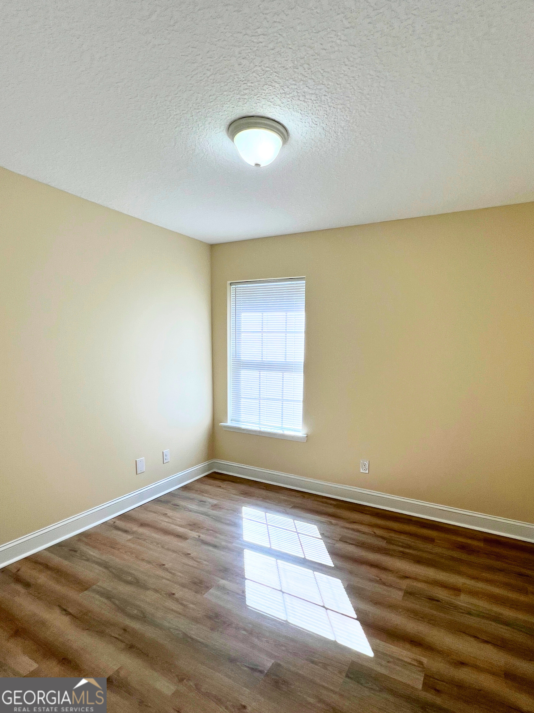 818 Davis Avenue Kingsland, GA 31548 - Photo 19 of 29 an empty room with wooden floor and windows