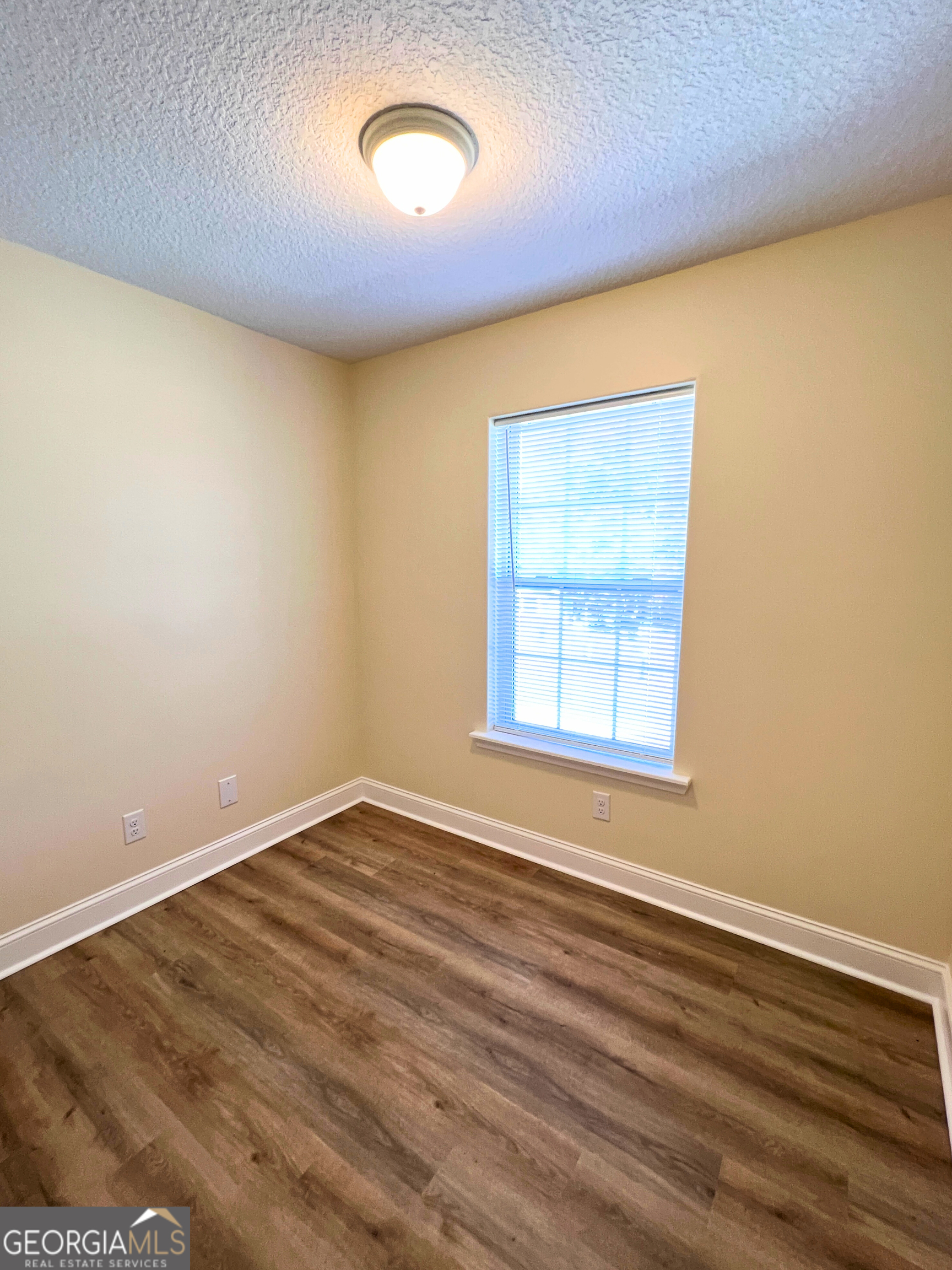 818 Davis Avenue Kingsland, GA 31548 - Photo 27 of 29 an empty room with wooden floor and windows