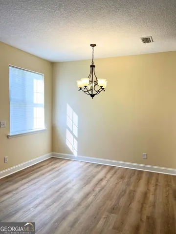 a view of a room with a window and wooden floor