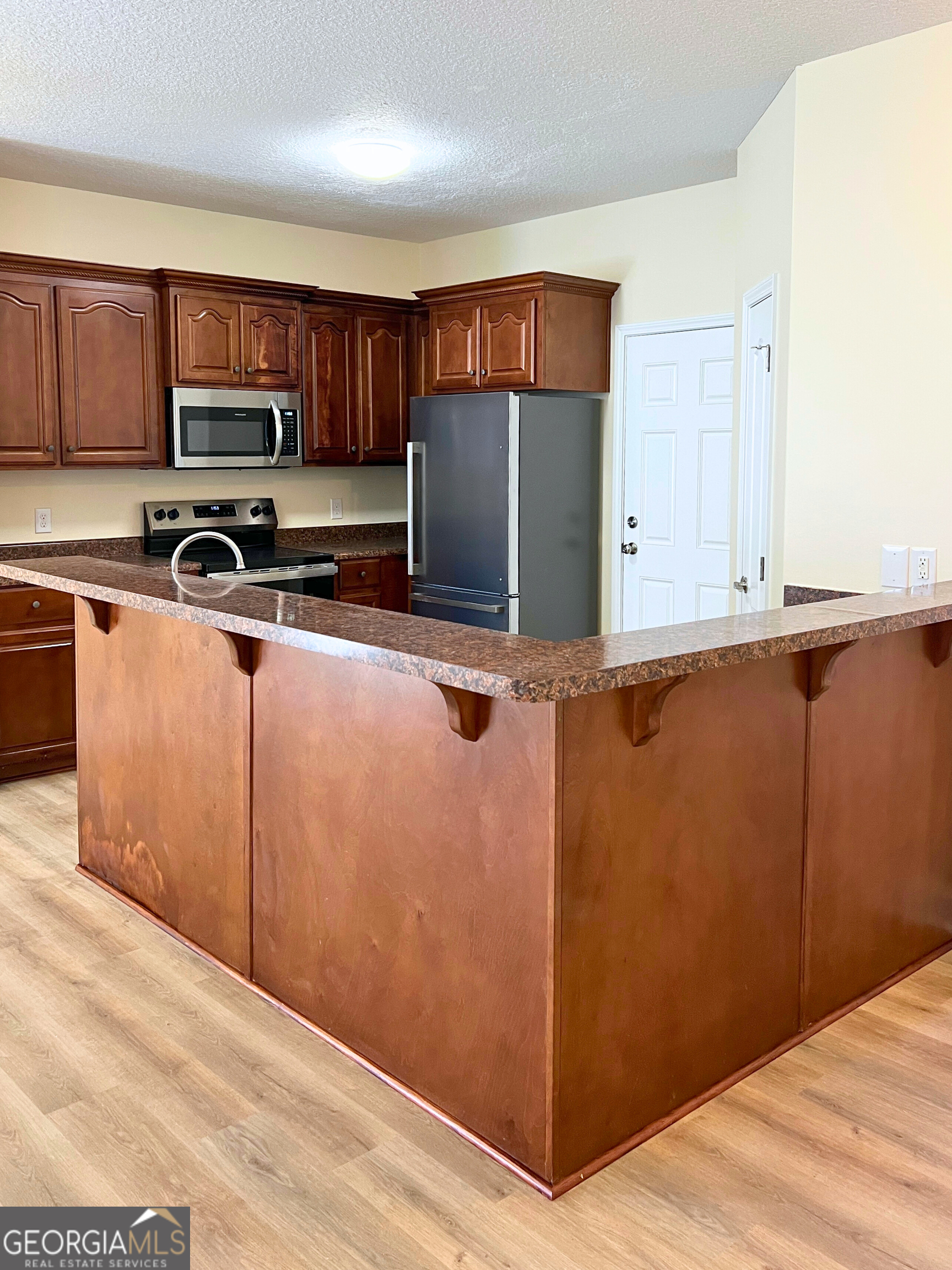 818 Davis Avenue Kingsland, GA 31548 - Photo 7 of 29 a kitchen with stainless steel appliances granite countertop a refrigerator microwave and sink