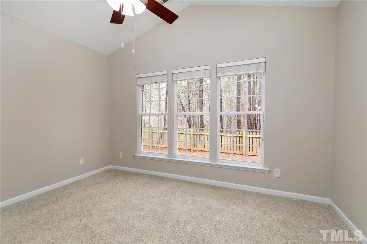 8424 Aztec Dawn Court Raleigh, NC 27613 - Photo 11 of 30 an empty room with chandelier fan and windows