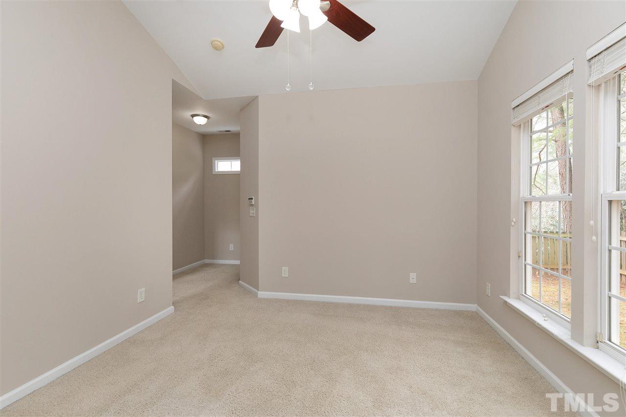 8424 Aztec Dawn Court Raleigh, NC 27613 - Photo 12 of 30 an empty room with chandelier fan and windows