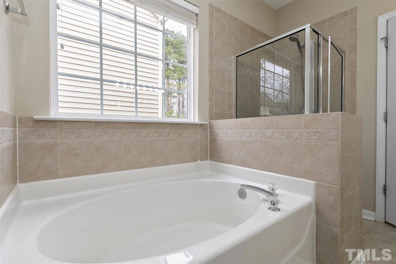 8424 Aztec Dawn Court Raleigh, NC 27613 - Photo 15 of 30 a white bath tub sitting in a bathroom next to a window