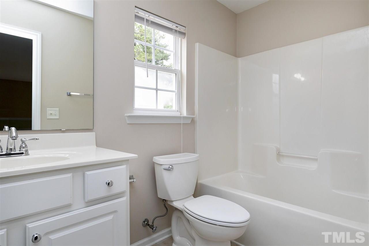 8424 Aztec Dawn Court Raleigh, NC 27613 - Photo 25 of 30 a bathroom with a granite countertop toilet a sink and a mirror