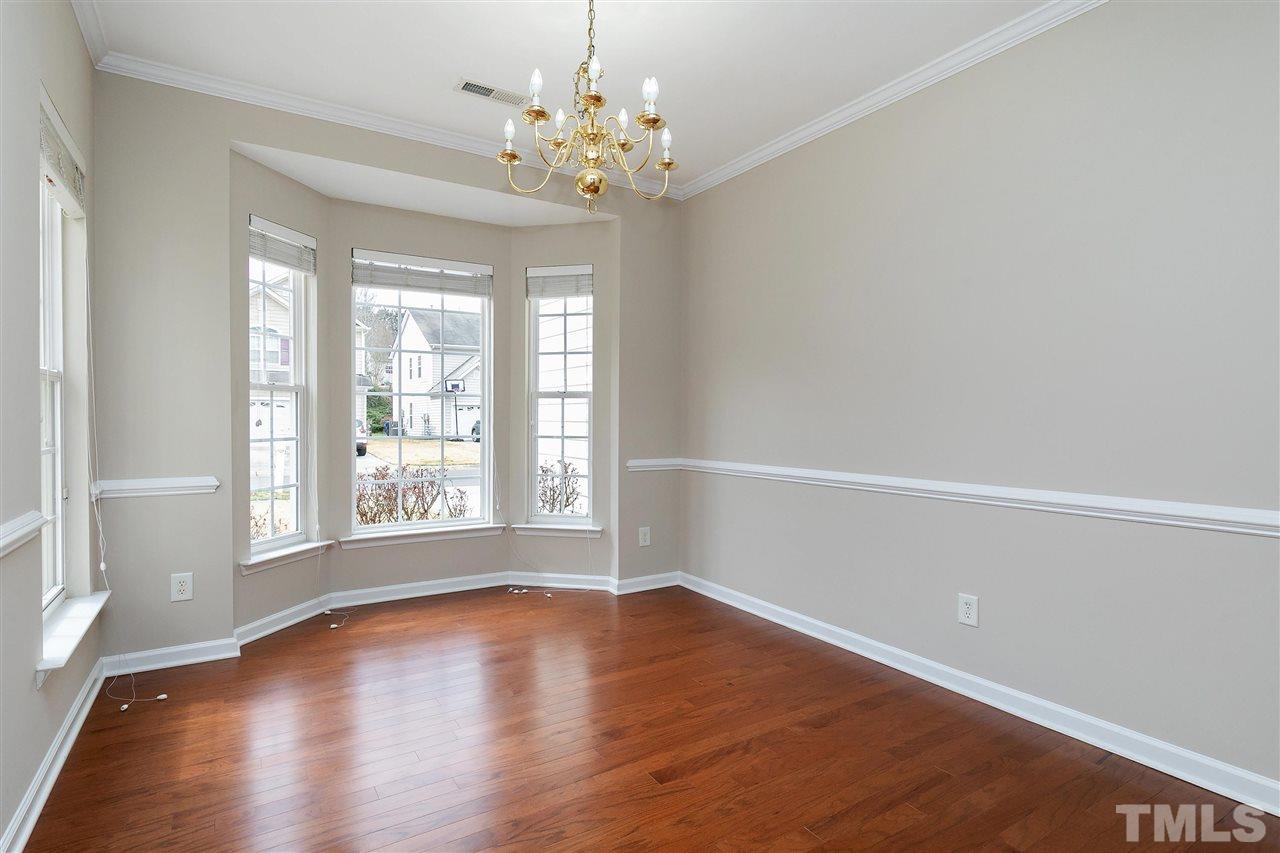 8424 Aztec Dawn Court Raleigh, NC 27613 - Photo 6 of 30 a view of an empty room with wooden floor and a window