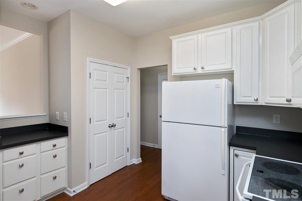 8424 Aztec Dawn Court Raleigh, NC 27613 - Photo 9 of 30 a white refrigerator freezer and a stove sitting inside of a kitchen