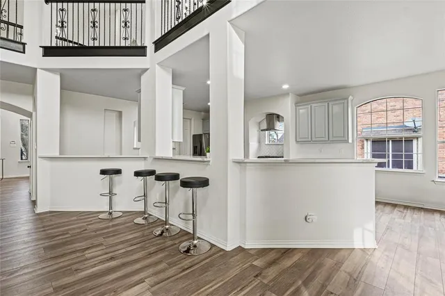 a view of a kitchen with wooden floor and seating space