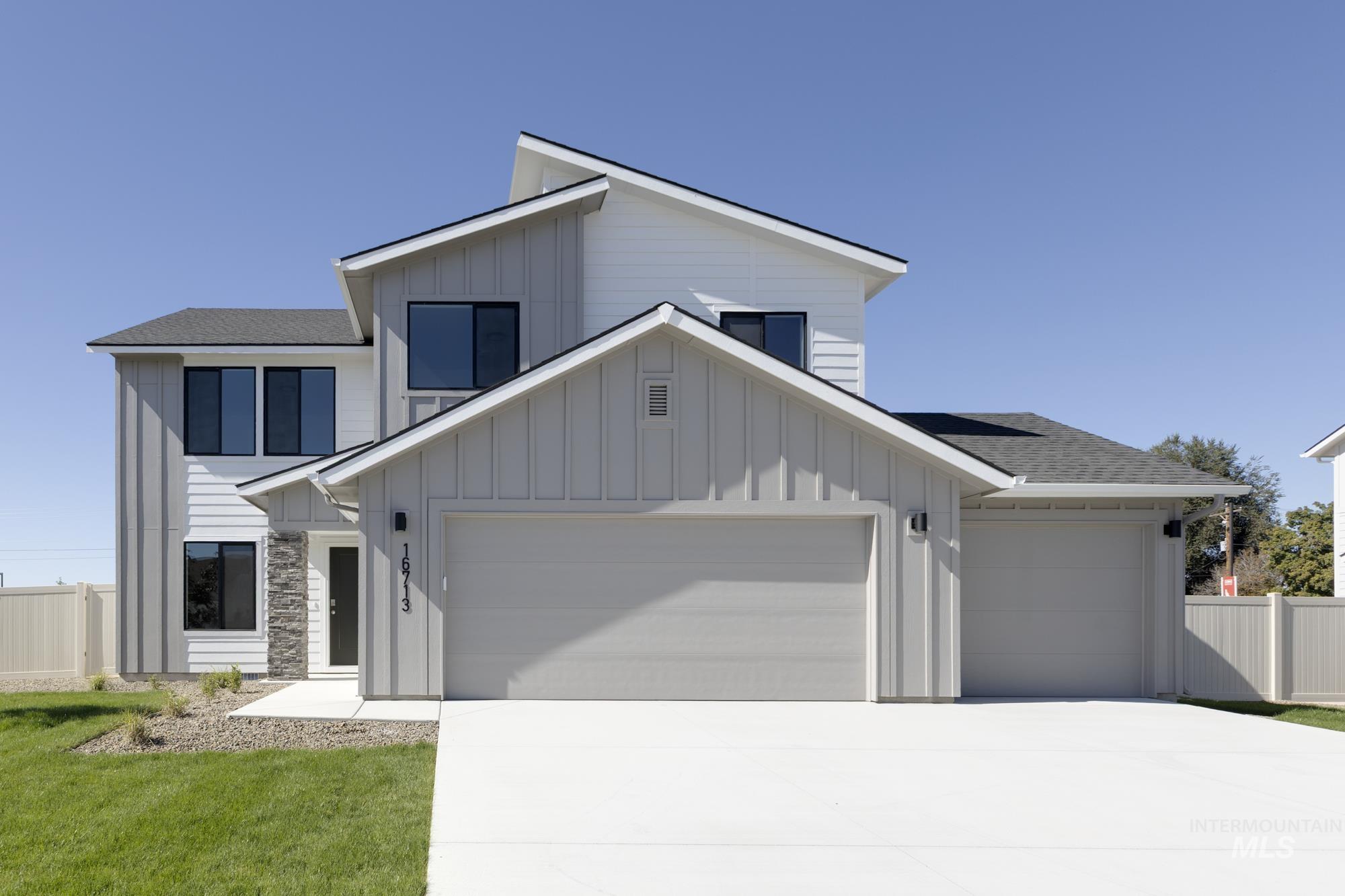 Modern farmhouse featuring board and batten siding, a shingled roof, concrete driveway, and a garage