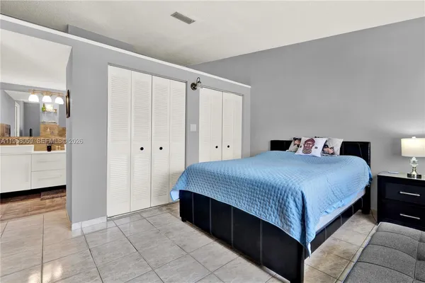 a spacious bedroom with a bed and a view of bathroom