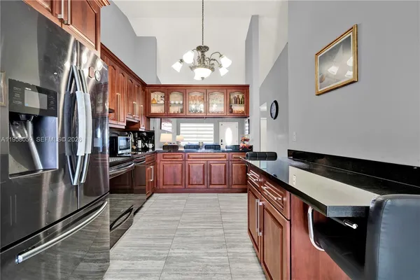 a kitchen with stainless steel appliances granite countertop a refrigerator and a stove