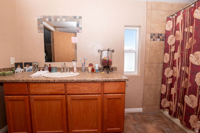 855 East 300 N Street Beaver, UT 84713 - Photo 22 of 44 Bathroom featuring a wood-finish vanity with a built-in sink and speckled countertop