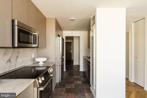 a kitchen with a refrigerator a stove and a wooden cabinets