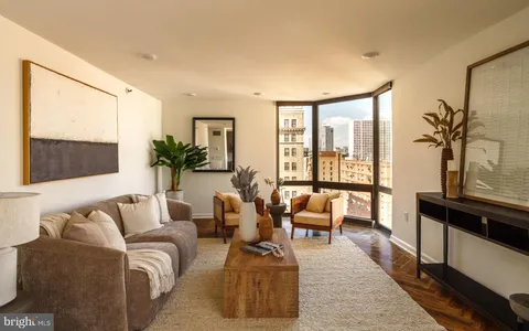 a living room with furniture and floor to ceiling windows