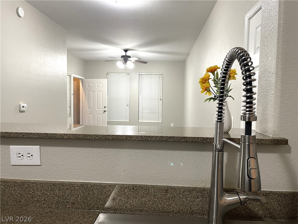 10001 Peace Way, Unit 1327 Las Vegas, NV 89147 - Photo 10 of 21 A well-appointed kitchen features a deep sink with a modern pull-down faucet and durable granite counters.