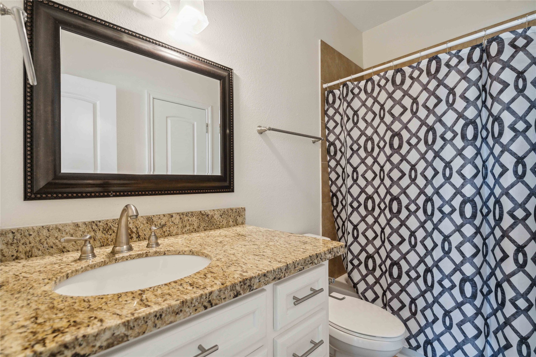 5402 Jonathan Lane Houston, TX 77011 - Photo 17 of 19 a bathroom with a granite countertop sink and a mirror