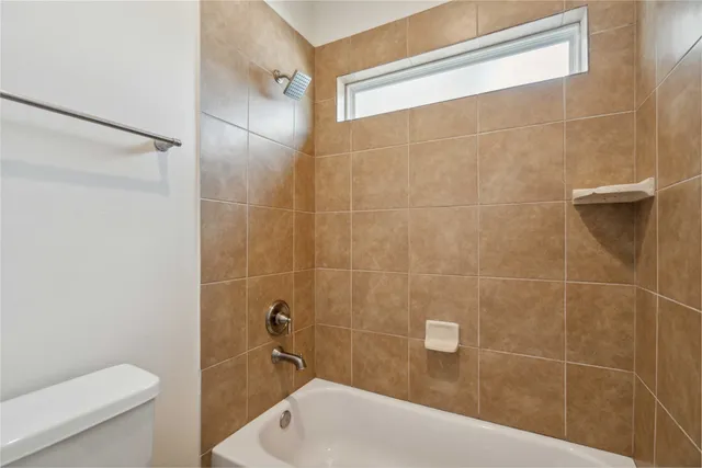 a bath tub sitting next to a white toilet and a shower
