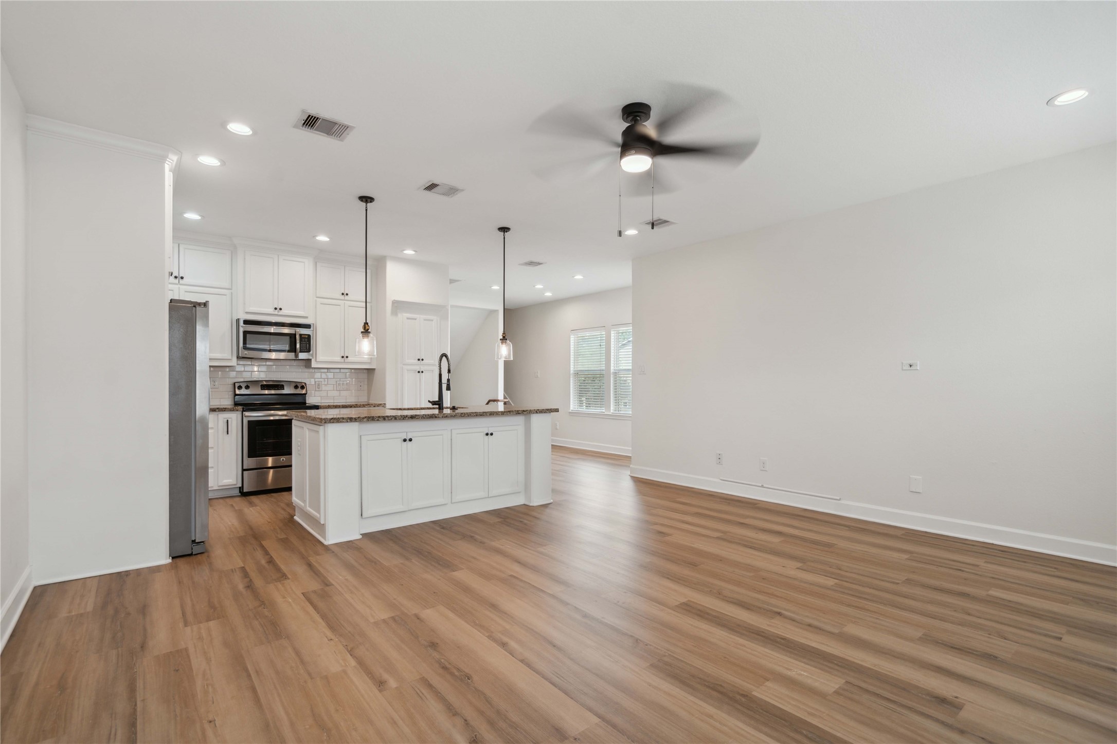 5402 Jonathan Lane Houston, TX 77011 - Photo 6 of 19 a large kitchen with stainless steel appliances granite countertop a lot of cabinets and wooden floor