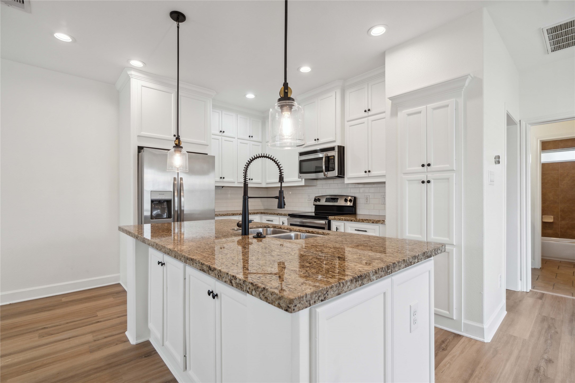 5402 Jonathan Lane Houston, TX 77011 - Photo 7 of 19 a kitchen with kitchen island granite countertop a sink a counter space appliances and cabinets