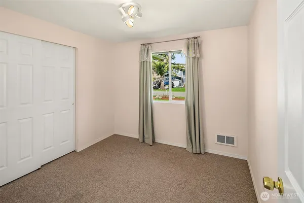 an empty room with windows and closet