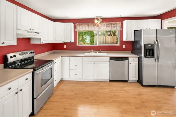 a kitchen with stainless steel appliances granite countertop a stove a sink and a refrigerator