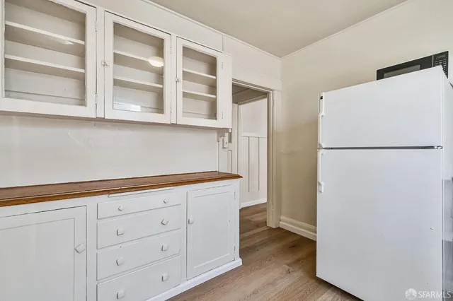 a kitchen with cabinets and a refrigerator