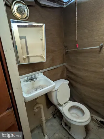 a bathroom with a toilet a sink and a mirror