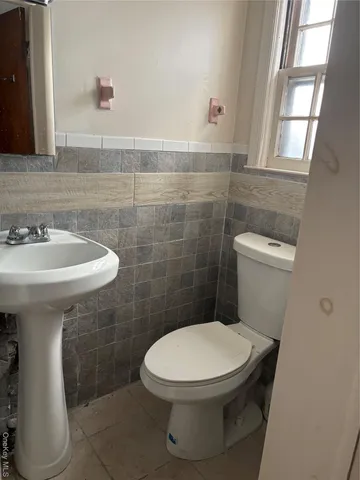 a white toilet sitting next to a bathroom sink