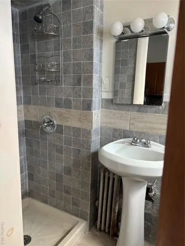 a bathroom with a sink shower and a mirror