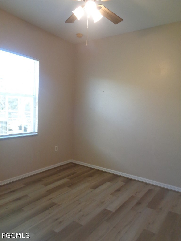 2463 Nature Pointe Loop Fort Myers, FL 33905 - Photo 35 of 50 an empty room with wooden floor and windows