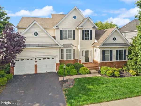 a front view of a house with a yard and trees
