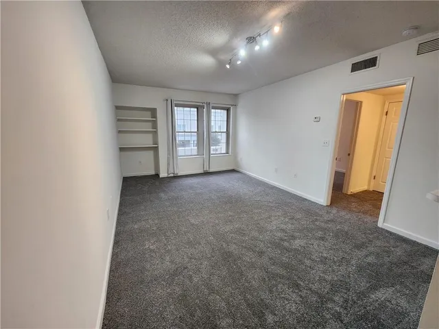 an empty room with windows and closet