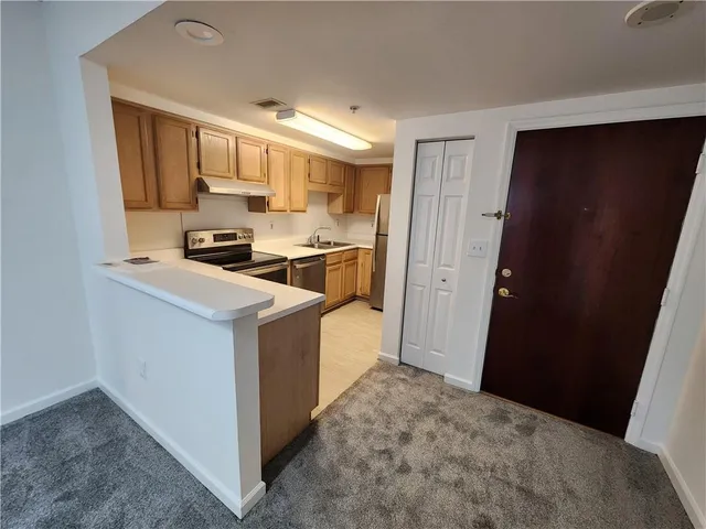 a kitchen with a refrigerator a stove top oven a sink and dishwasher