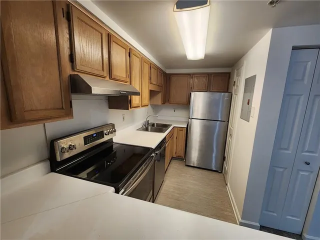 a kitchen with a refrigerator and a stove top oven
