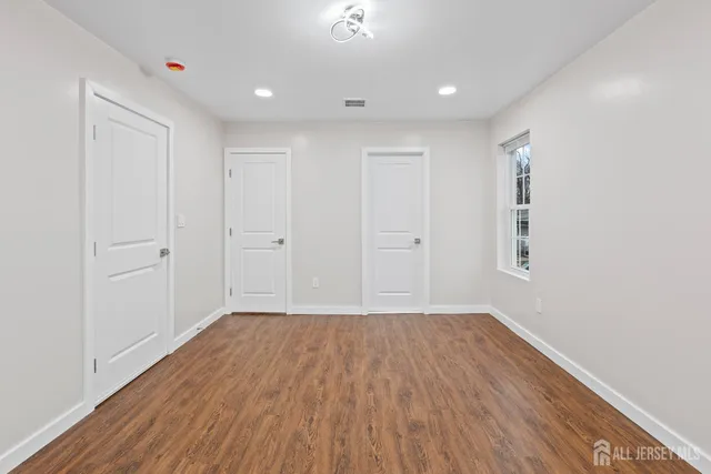 a view of a room with wooden floor and white walls