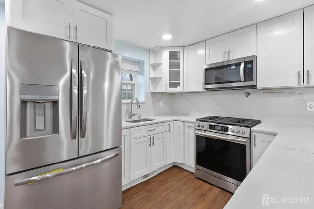 a kitchen with stainless steel appliances wooden cabinets and a stove top oven