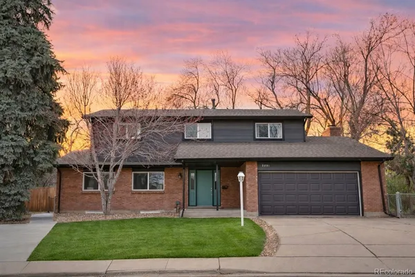 a front view of a house with a garden and trees