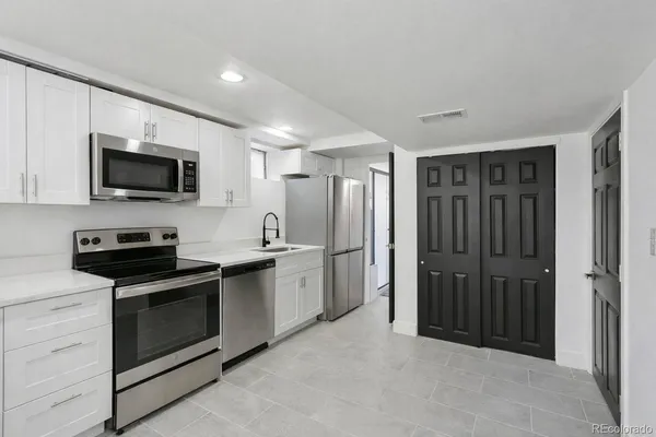 a kitchen with stainless steel appliances stove microwave refrigerator and cabinets
