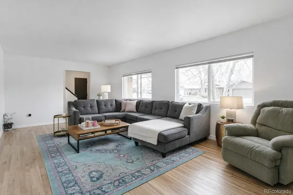 a living room with furniture wooden floor and a large window