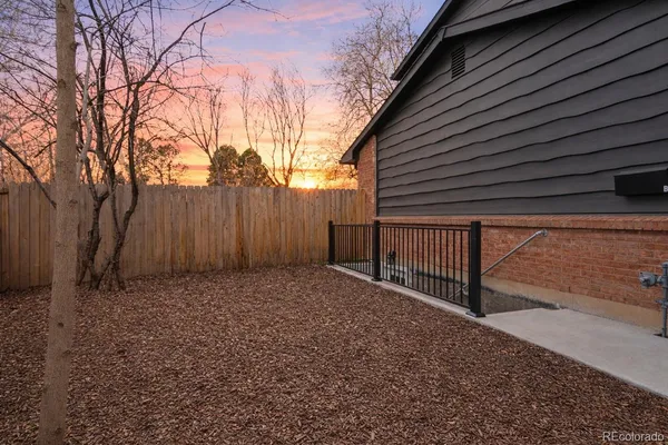 a view of backyard with wooden fence