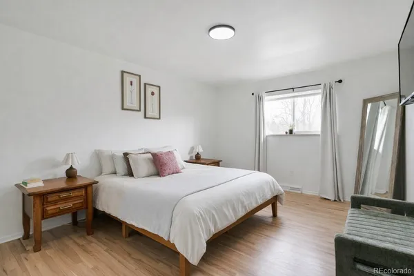 a bedroom with a bed and wooden floor