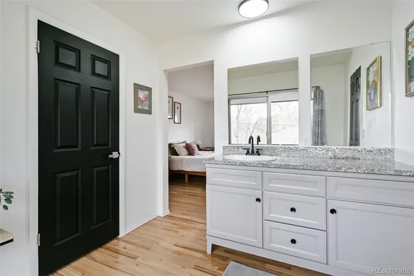 a bathroom with a granite countertop sink and a mirror