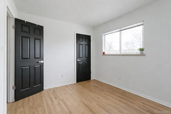 a view of an empty room with wooden floor