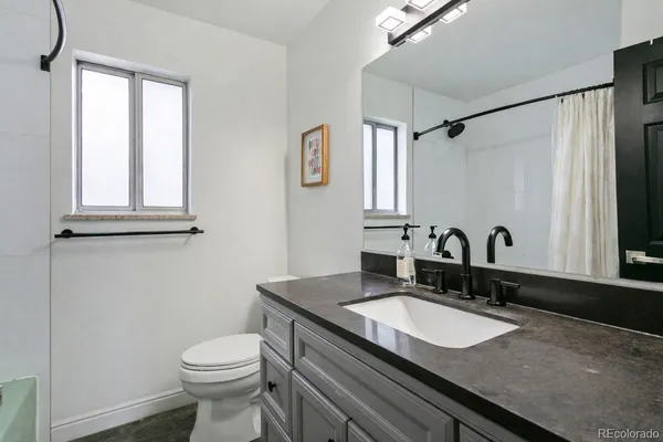 a bathroom with a granite countertop sink and a mirror