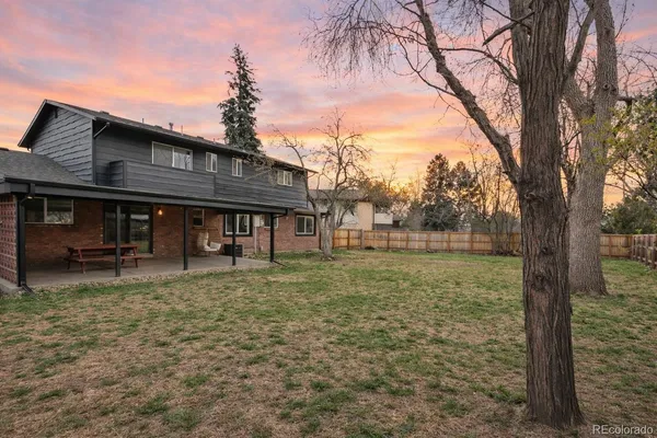 a backyard of a house with fountain table and chairs