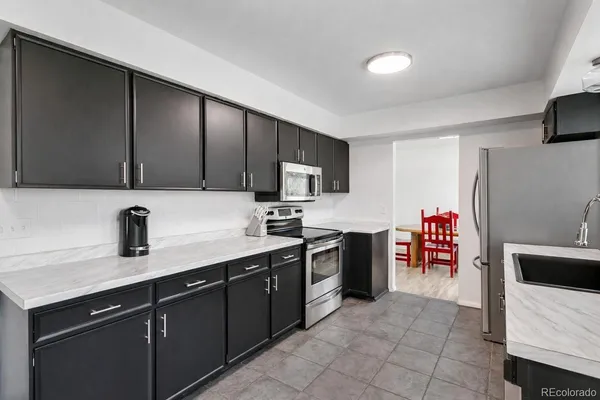 a kitchen with stainless steel appliances granite countertop a sink counter space and cabinets