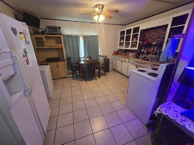 a view of a storage & utility room with refrigerator and washer