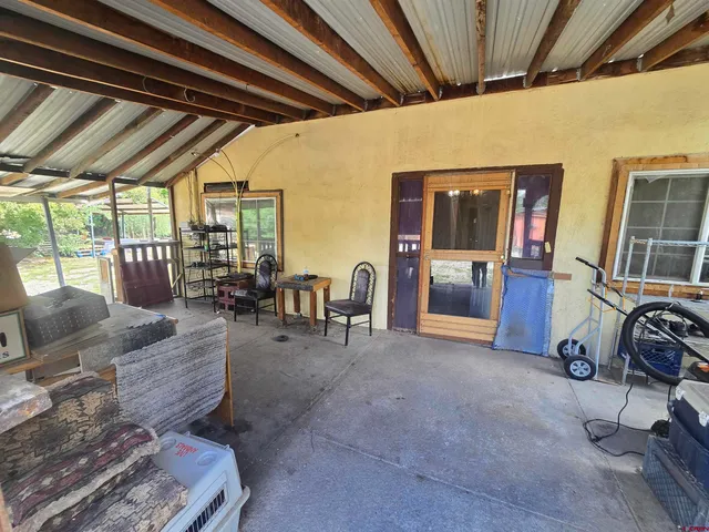 a view of a patio with table and chairs with wooden floor and fence