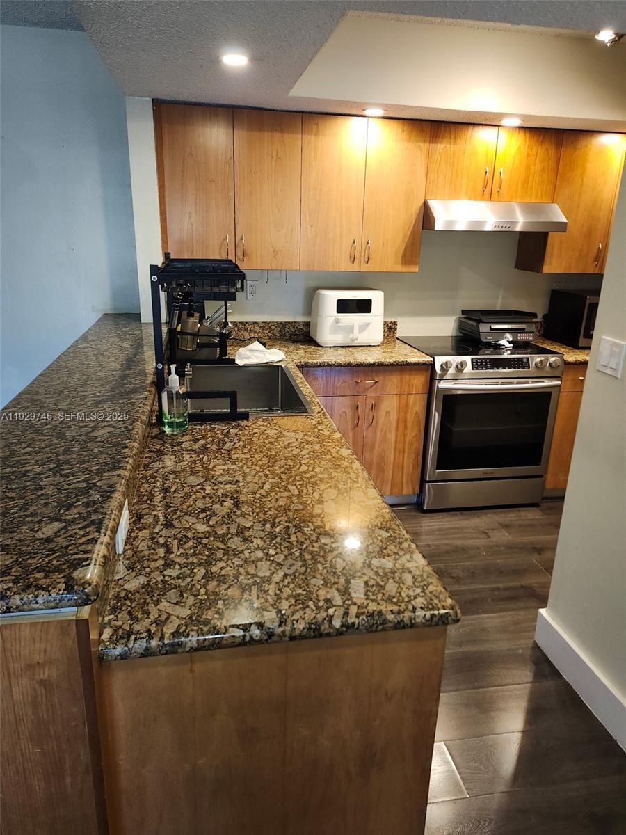 a kitchen with a sink a stove and chairs